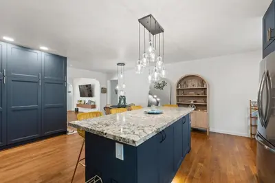 a kitchen with blue cabinets and a kitchen island at Midtown Bungalow in Reno
