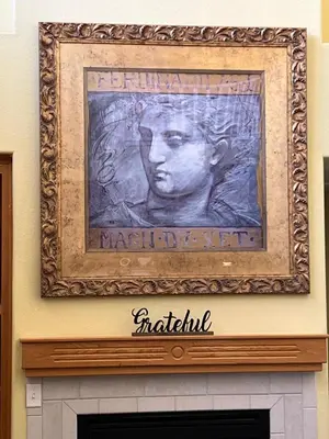 a painting of a man over a fireplace at Cozy room at la paz in Fresno