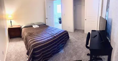 a bedroom with a bed and a dresser and a television at Cozy room at la paz in Fresno