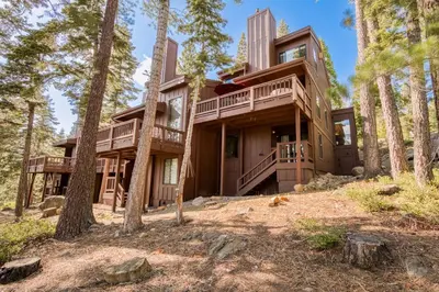 a house in the woods with trees at Northshore Lakeside Condo 15 by Tahoe Getaways - Walk to Beach with HOA in Tahoe City