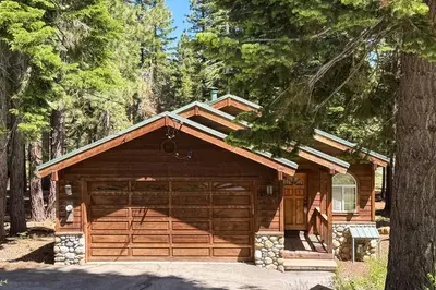 a large wooden garage in the middle of a forest at The Tahoe House in Truckee
