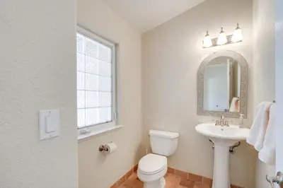 a bathroom with a toilet and a sink and a mirror at Mtn Views and Game Room Family Retreat in Groveland in Groveland