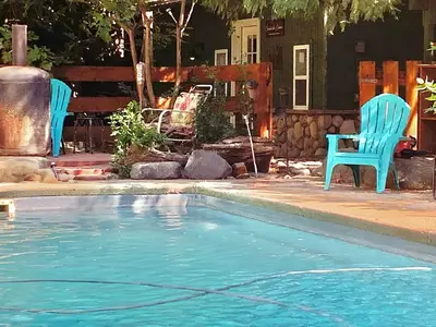 two blue chairs sitting next to a swimming pool at Shady Creekside Cabin in Miramonte