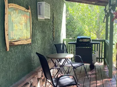 a patio with a table and chairs and a grill at Shady Creekside Cabin in Miramonte