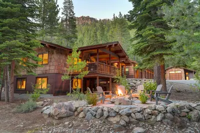 a log cabin with a fire in front of it at Big Chief River Retreat-Located on Truckee River in Truckee