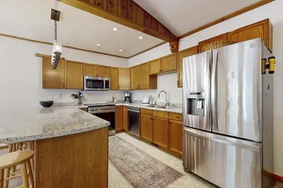 a kitchen with wooden cabinets and a stainless steel refrigerator at West End Escape in Truckee