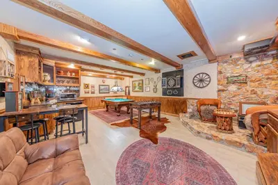 a living room filled with furniture and a stone wall at Vintage Sunset Villa by Bass Lake 17 miles from Yosemite National Park in Oakhurst