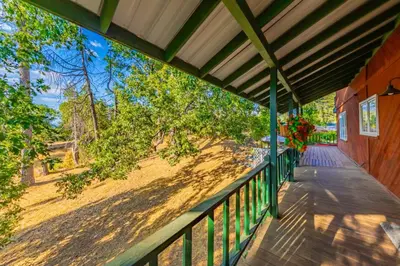 a porch of a house with a wooden fence at Vintage Sunset Villa by Bass Lake 17 miles from Yosemite National Park in Oakhurst