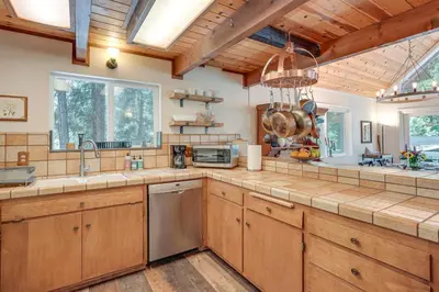 a kitchen with wooden cabinets and a large counter top at Private Lake Access Pet-Friendly Home in Arnold! in Arnold