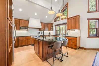 a kitchen with wooden cabinets and a island with a sink at Wintergreen at Tahoe Donner by Tahoe Getaways - 3BR w HOA! in Truckee