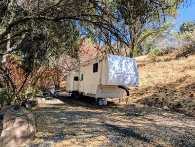 a white trailer parked in a field under trees at Sierra Escape RV in Squaw Valley