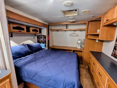 a small bedroom with a blue bed in an rv at Sierra Escape RV in Squaw Valley