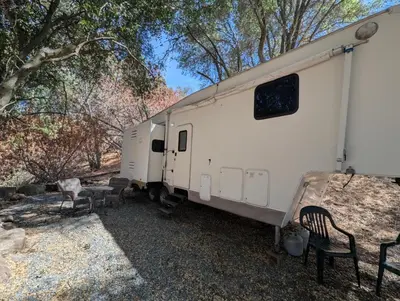 a white trailer with a table and chairs and trees at Sierra Escape RV in Squaw Valley