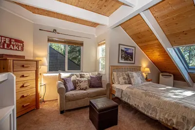 a bedroom with a bed and a couch and a window at Dollar Hill II # 61 By Hauserman Rentals in Tahoe City