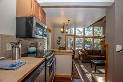a kitchen with a stove top oven next to a living room at Dollar Hill II # 61 By Hauserman Rentals in Tahoe City