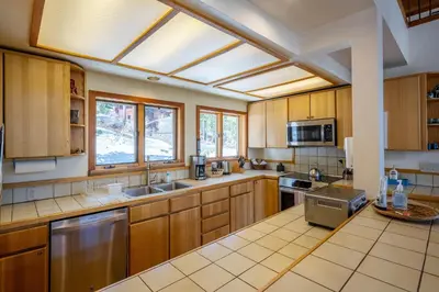 a large kitchen with wooden cabinets and a skylight at Alpine Retreat By Hauserman Rentals in Tahoe City