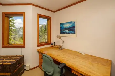an office with a desk and a chair and windows at Alpine Retreat By Hauserman Rentals in Tahoe City