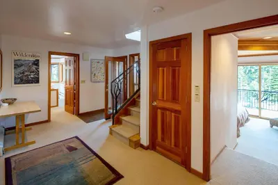 a hallway with wooden doors and stairs with a table at Alpine Retreat By Hauserman Rentals in Tahoe City