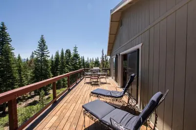 a deck with chairs and a table on the side of a building at Goetzl By Hauserman Rentals in Tahoma