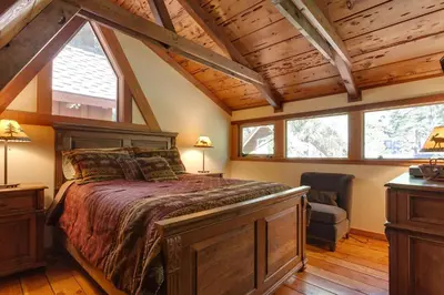 a bedroom with a large bed and a chair at Hoeck Hacienda By Hauserman Rentals in Tahoe City