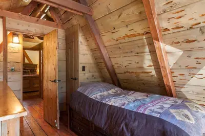 a bedroom in a log cabin with a bed at Hoeck Hacienda By Hauserman Rentals in Tahoe City