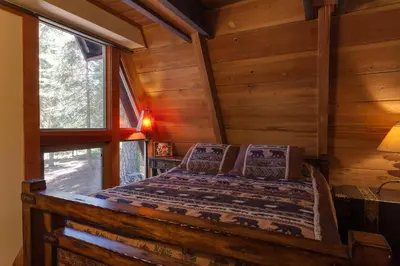 a bedroom with a bed in a log cabin at Hoeck Hacienda By Hauserman Rentals in Tahoe City