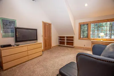 a living room with a television on a wooden dresser at Celtic Lodge By Hauserman Rentals in Homewood