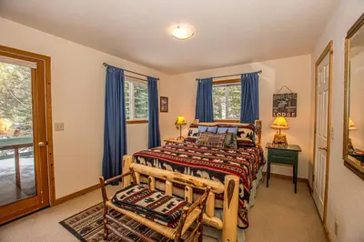 a bedroom with a bed and two chairs and a window at Carnelian Bay Hideaway By Hauserman Rentals in Carnelian Bay