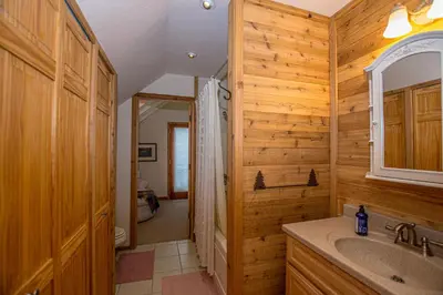 a wooden bathroom with a sink and a mirror at Carnelian Bay Hideaway By Hauserman Rentals in Carnelian Bay