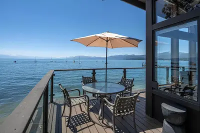 a table with chairs and an umbrella on a dock at Star Harbor # 10 By Hauserman Rentals in Tahoe City