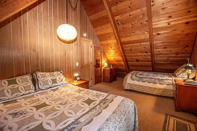 a bedroom with two beds in a log cabin at Das Berghaus By Hauserman Rentals in Tahoe City