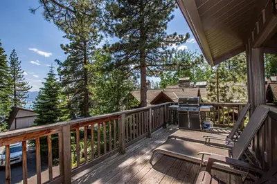 a deck with chairs and a grill on a house at Coates By Hauserman Rentals in Tahoe City