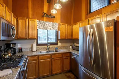 a kitchen with wooden cabinets and a stainless steel refrigerator at Grainger By Hauserman Rentals in Tahoe City