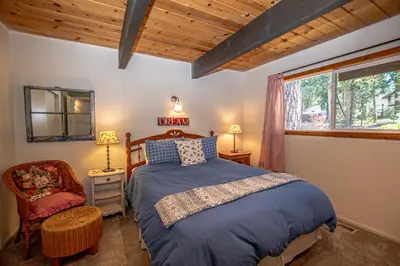 a bedroom with a bed and a chair and a window at Alpine Welcome By Hauserman Rentals in Tahoe City