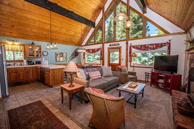 a living room with a couch and a kitchen at Alpine Welcome By Hauserman Rentals in Tahoe City