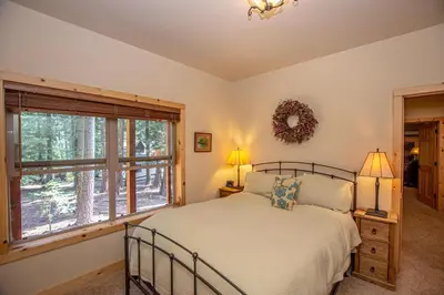 a bedroom with a bed and a large window at Tahoe Woods By Hauserman Rentals in Tahoe City