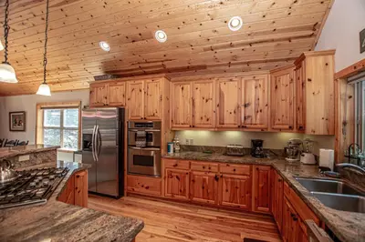 a kitchen with wooden cabinets and a stainless steel refrigerator at Tahoe Woods By Hauserman Rentals in Tahoe City
