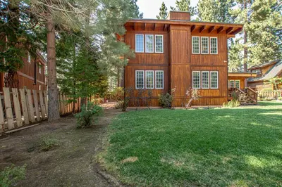 a wooden house with a fence and a yard at Dollar Point Lodge By Hauserman Rentals in Tahoe City