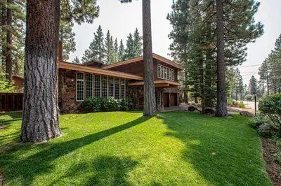 a house in the woods with trees in the yard at Dollar Point Lodge By Hauserman Rentals in Tahoe City