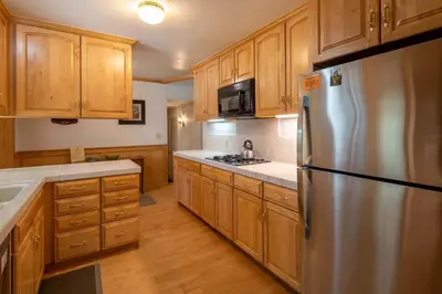 a kitchen with wooden cabinets and a stainless steel refrigerator at Dollar Point Lodge By Hauserman Rentals in Tahoe City