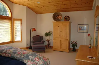 a bedroom with a bed and a chair and a cabinet at Going By Hauserman Rentals in Homewood