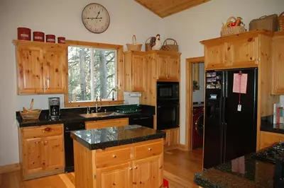 a kitchen with wooden cabinets and a black refrigerator at Going By Hauserman Rentals in Homewood