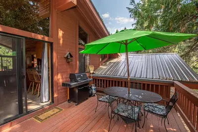 a table with a green umbrella on a deck at Vance By Hauserman Rentals in Tahoe City