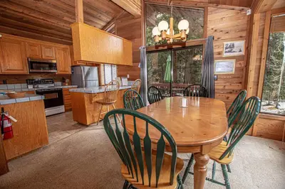 a kitchen and dining room with a wooden table and chairs at Vance By Hauserman Rentals in Tahoe City