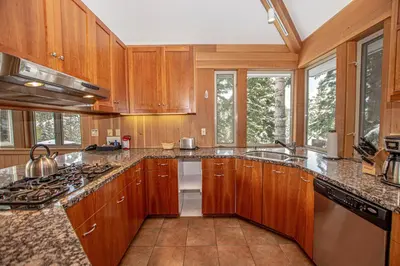 a kitchen with wooden cabinets and a sink at Snow Crest By Hauserman Rentals in Alpine Meadows