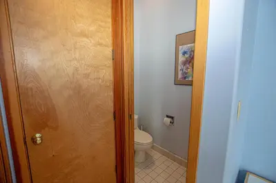 a bathroom with a toilet and a wooden door at Snow Crest By Hauserman Rentals in Alpine Meadows
