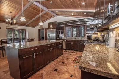 a large kitchen with wooden cabinets and granite counter tops at Highlands Lodge By Hauserman Rentals in Tahoe City