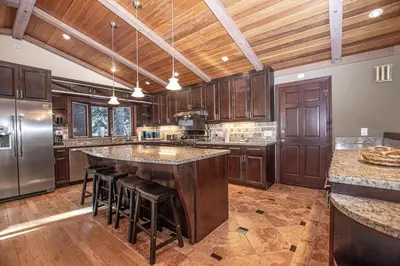 a large kitchen with a large island with bar stools at Highlands Lodge By Hauserman Rentals in Tahoe City