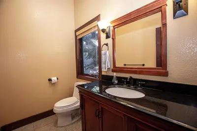 a bathroom with a sink and a toilet and a mirror at Highlands Lodge By Hauserman Rentals in Tahoe City