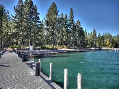 a river with a dock and trees on the shore at Black Bear Haus By Hauserman Rentals in Tahoe City